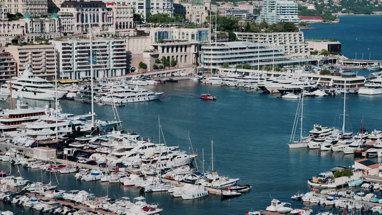 Vista aerea delle barche ormeggiate nel porto turistico di Monaco, con lo skyline della città sullo sfondo