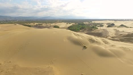 aerial view of a boogie car jumping the sand dunes in medanos de coro, falcon, venezuela