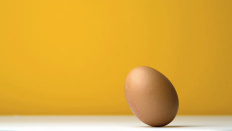 Egg-revolving-against-yellow-background