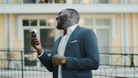 Laughing-businessman-having-video-chat-outside.-Afro-man-having-talk-outdoors