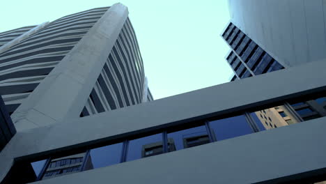 the low angle panning view of the city skyline buildings and blue sky