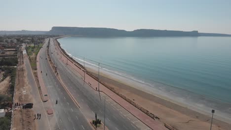 Aerial-Dolly-Direkt-über-Der-Marine-Drive-Neben-Der-Strandküste-In-Gwadar-Mit-Vorbeifahrendem-Verkehr