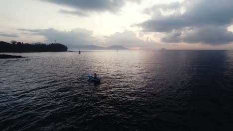 Antena-Establecida-De-Un-Barco-De-Pescadores-De-Madera-En-La-Isla-De-Bali,-Indonesia,-Agua-Del-Océano-Al-Atardecer