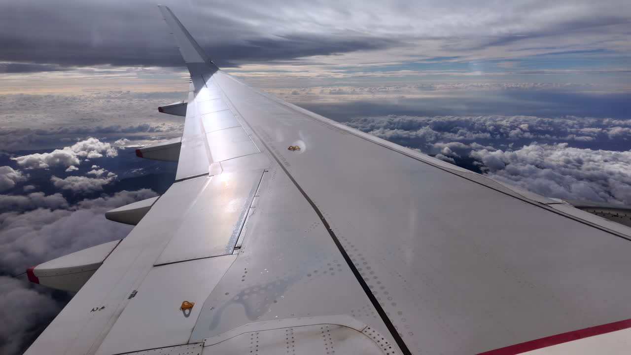 View from an airplane window of the aircraft wing in the clouds