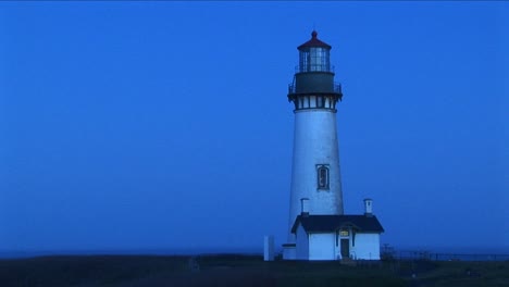 a white flashing beacon breaks up the blue tones of this footage of a lighthouse