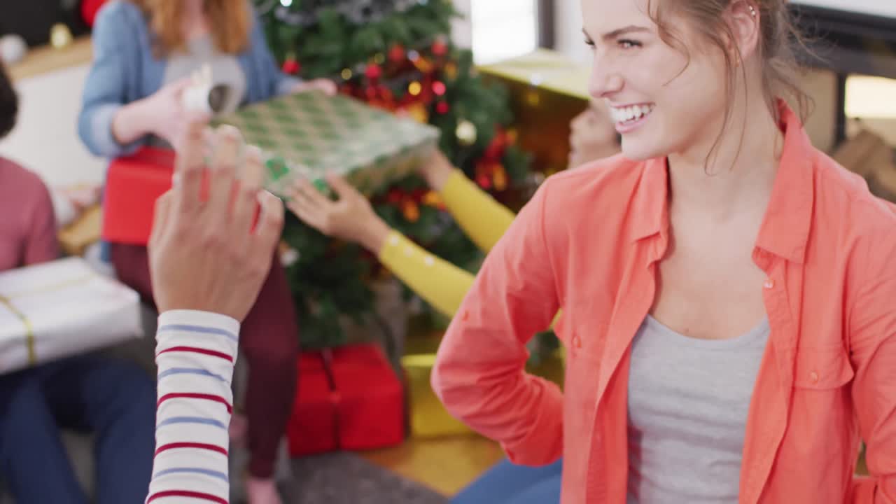 un grupo feliz de amigos diversos abriendo regalos de navidad