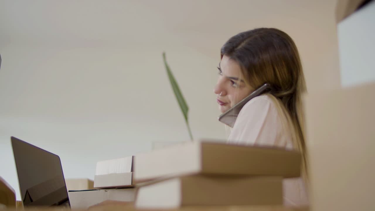 joven propietaria de una startup consultando a un cliente por teléfono