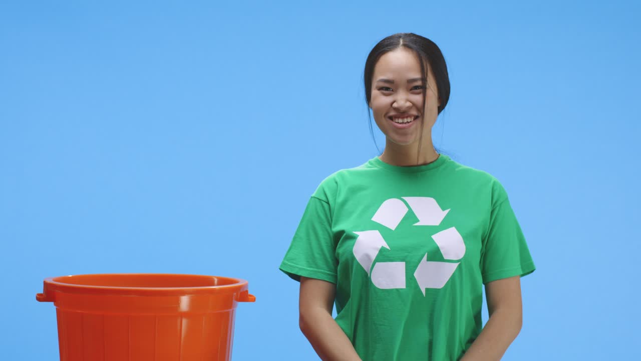 mujer eco-consciente poniendo botella en el cubo