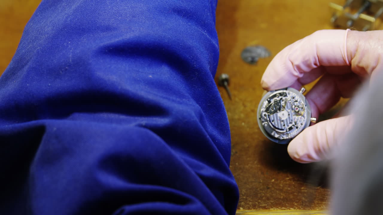 primer plano de las manos de un relojero reparando un reloj