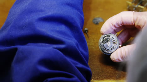 Close-up-of-horologist-hands-repairing-a-watch