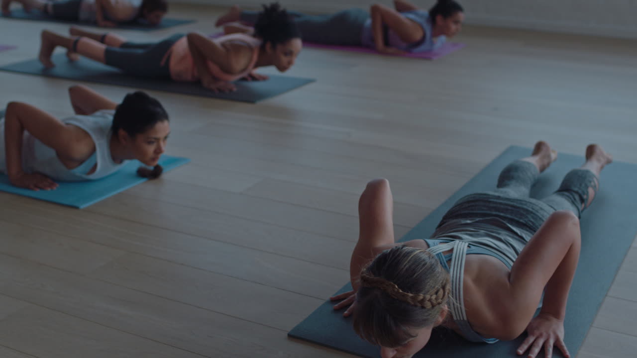 clase de yoga de mujeres sanas que practican la pose de cobra disfrutando del ejercicio en el gimnasio instructor líder grupo meditación enseñando postura de entrenamiento al amanecer