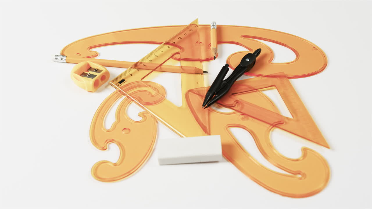 Close up of compass, pencil, sharpener, eraser and rulers on white background, slow motion