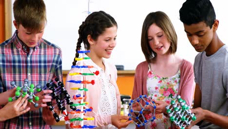 School-students-experimenting-molecule-model-in-laboratory