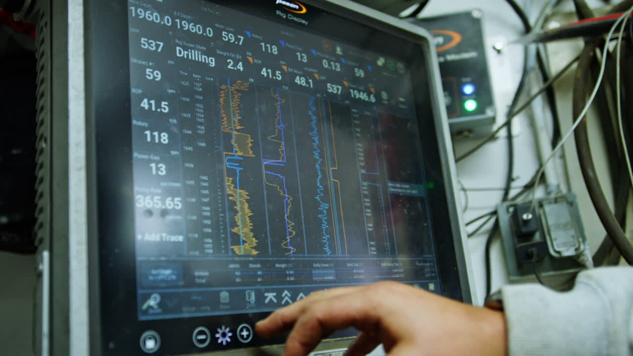 Male hand setting the parameters at the computerized equipment for drilling natural resources. Close up. Natural resources production concept.