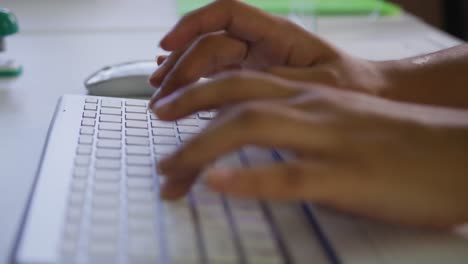 Close-up-of-mixed-race-businesswoman's-hands-typing-on-computer-keyboard