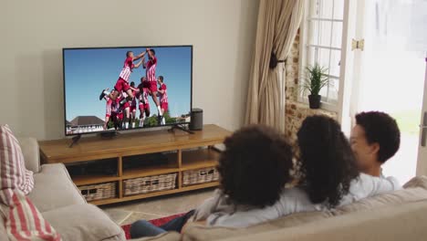 composite of happy family sitting at home together watching football match on tv