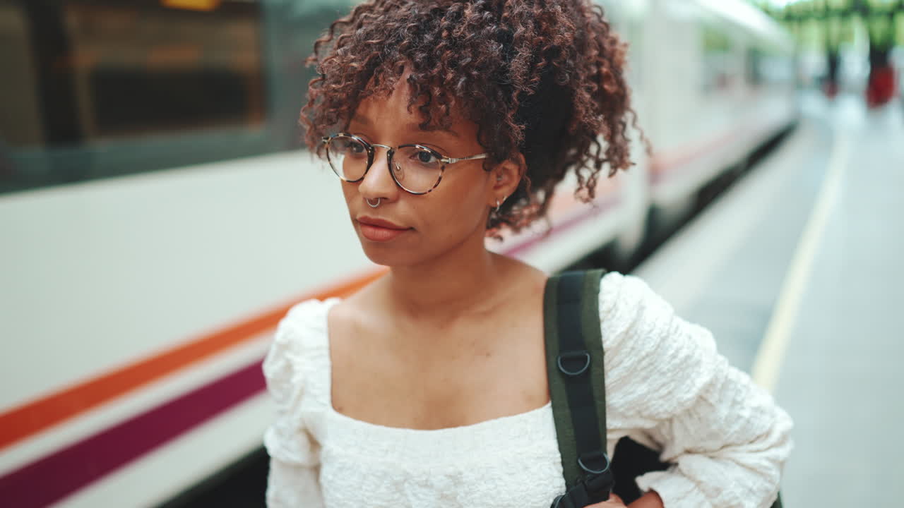 Woman with curly hair at a train platform