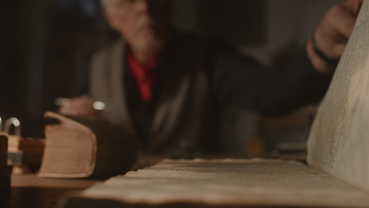 Old passionate man writes a letter in his office at night