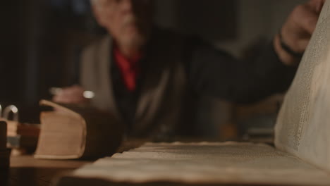 old passionate man writes a letter in his office at night