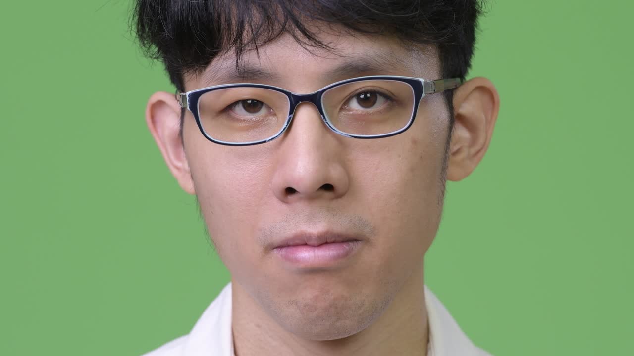 녹색 배경 에 있는 젊은 아시아인 사업가 의 머리