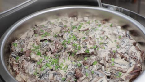 big bowl of chicken in white sauce at buffet restaurant