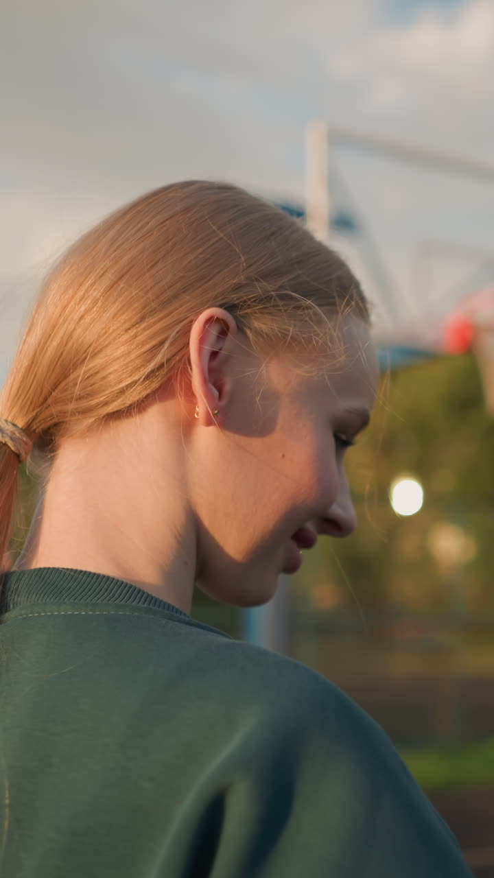 primer plano de dos damas jugando al voleibol mientras sonríen, con un aro de baloncesto en el fondo, se pueden ver árboles y edificios, creando un entorno al aire libre animado