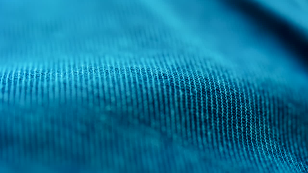 Close up of blue fabric texture showing fine threads and detailed textile pattern