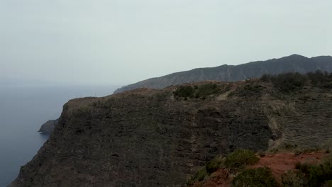 Aerial-view-of-rocky-coastline-with-sharp-cliffs-in-Abrante-viewpoint,-La-Gomera,-Canary-Islands-on-a-foggy-day