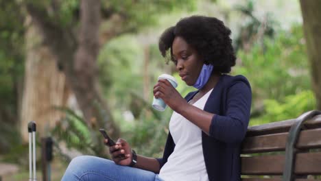 African-american-woman-wearing-face-mask-in-park