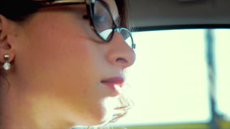 attractive caucasian business woman driving, with a neutral expression - close up