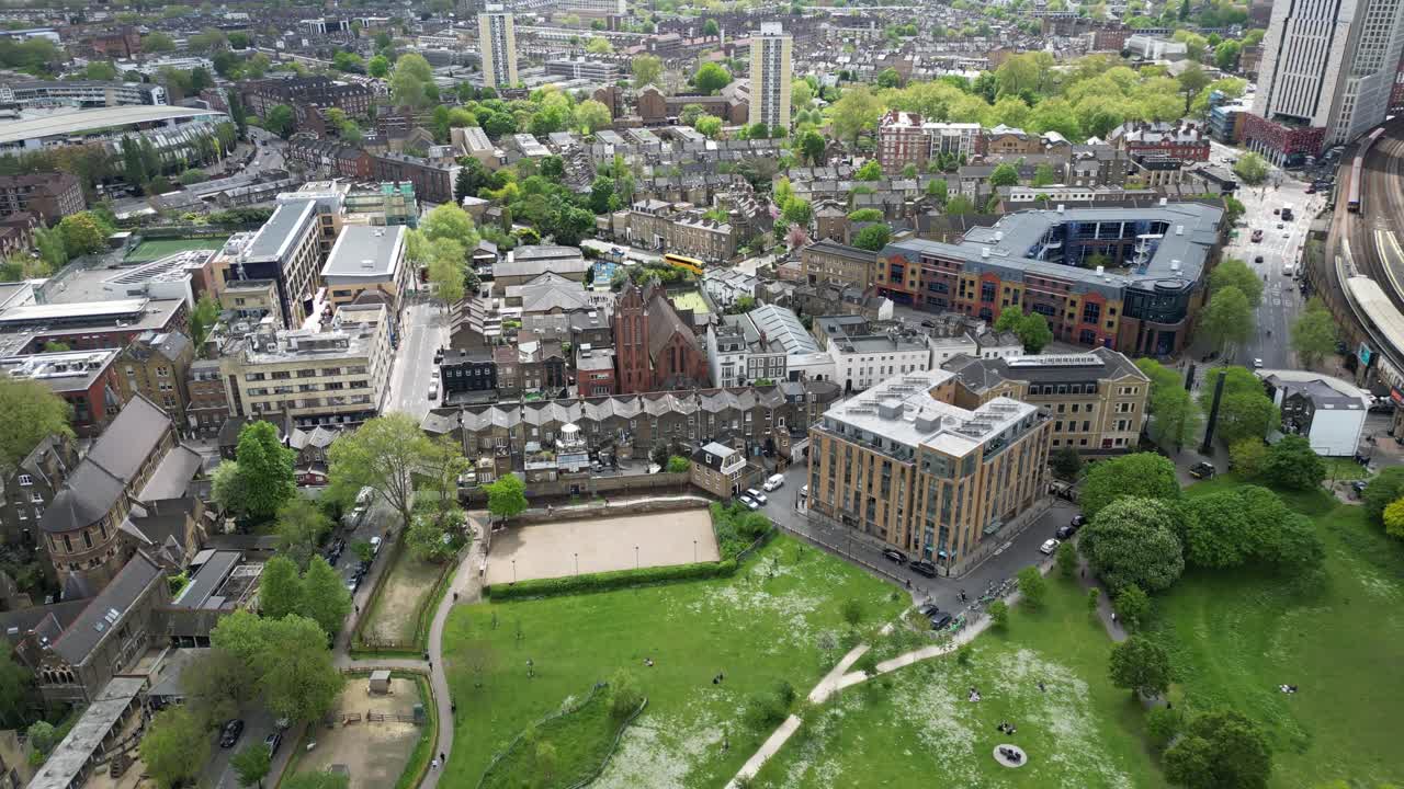 Calm 4K drone shot flying over a suburban park in London during daytime. Slow motion capable, perfect for lifestyle, nature, urban greenery, or travel projects