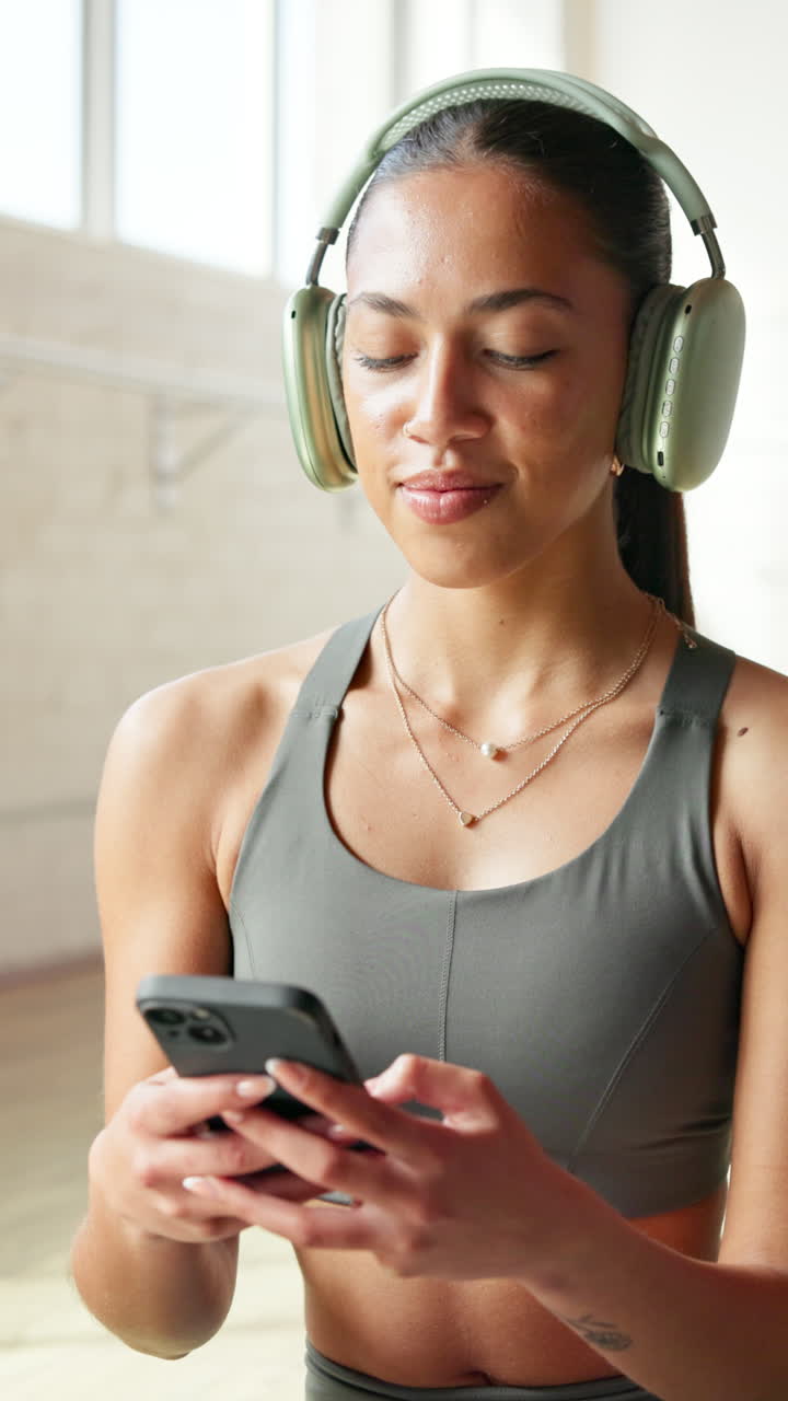 Giovane donna con cuffie che usa lo smartphone in interni