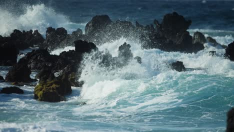 powerful waves crashing on volcanic rocks