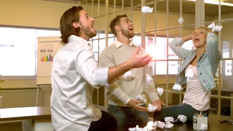 creative team throwing crumpled balls of paper