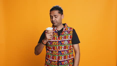 hombre cansado bebiendo café, aislado sobre el fondo del estudio