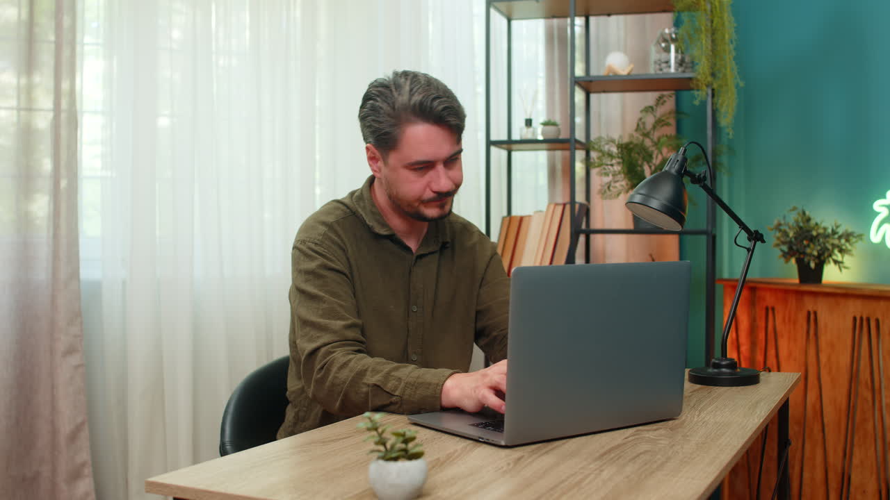 Middleaged man rubs neck closing laptop annoyed pain posture fatigue after lengthy desk work table