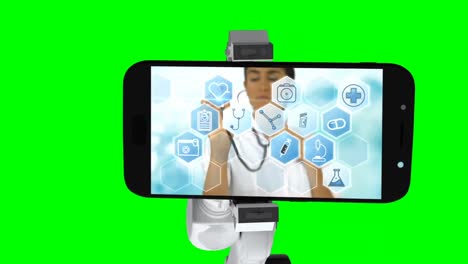 digitally generated video of white robotic arm holding mobile phone that show medical icons on scree