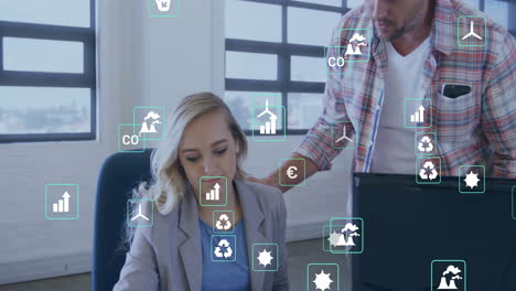 animación de iconos de ecología sobre colegas caucásicos usando computadora en la oficina
