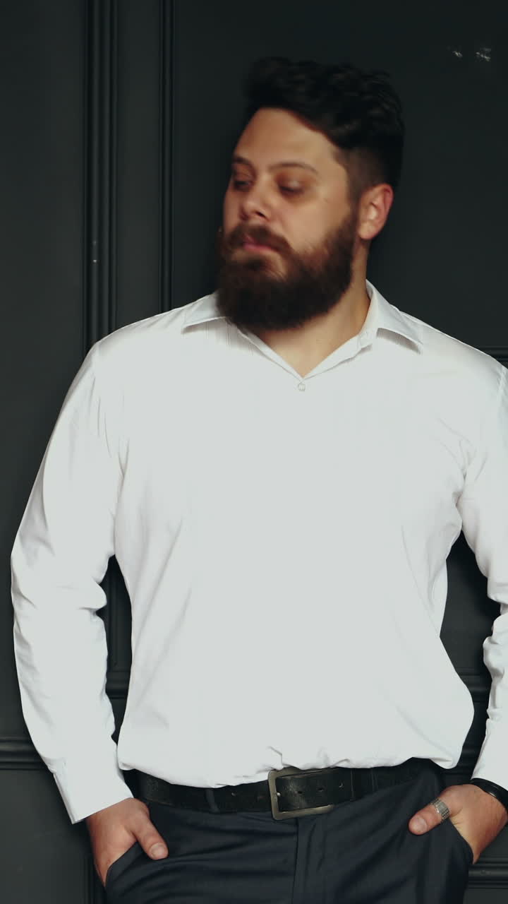 Brutal man in studio. Young casual bearded man posing in studio Vertical video