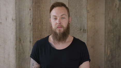 young hipster punk man with beard looking calm pensive handsome independent male confident successful tattoo