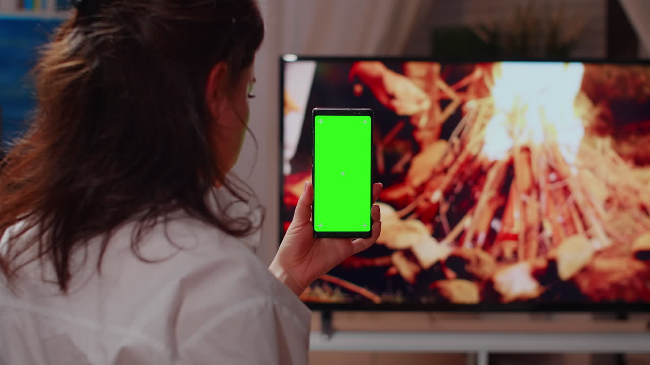 Giovane adulto che guarda lo smartphone con schermo verde