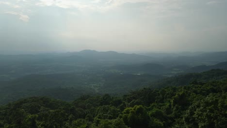 Imágenes-Aéreas-Ascendentes-De-Este-Pintoresco-Paisaje-Con-Exuberante-Selva-Tropical-En-El-Frente,-Montañas-Y-Valles-Abajo,-Capturadas-Durante-La-Tarde