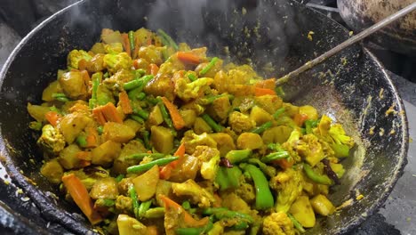 frying fresh cabbage coconut sabzi or vegetable with turmeric powder also known as patta gobi ki sabji, stir at a road side dhaba in india