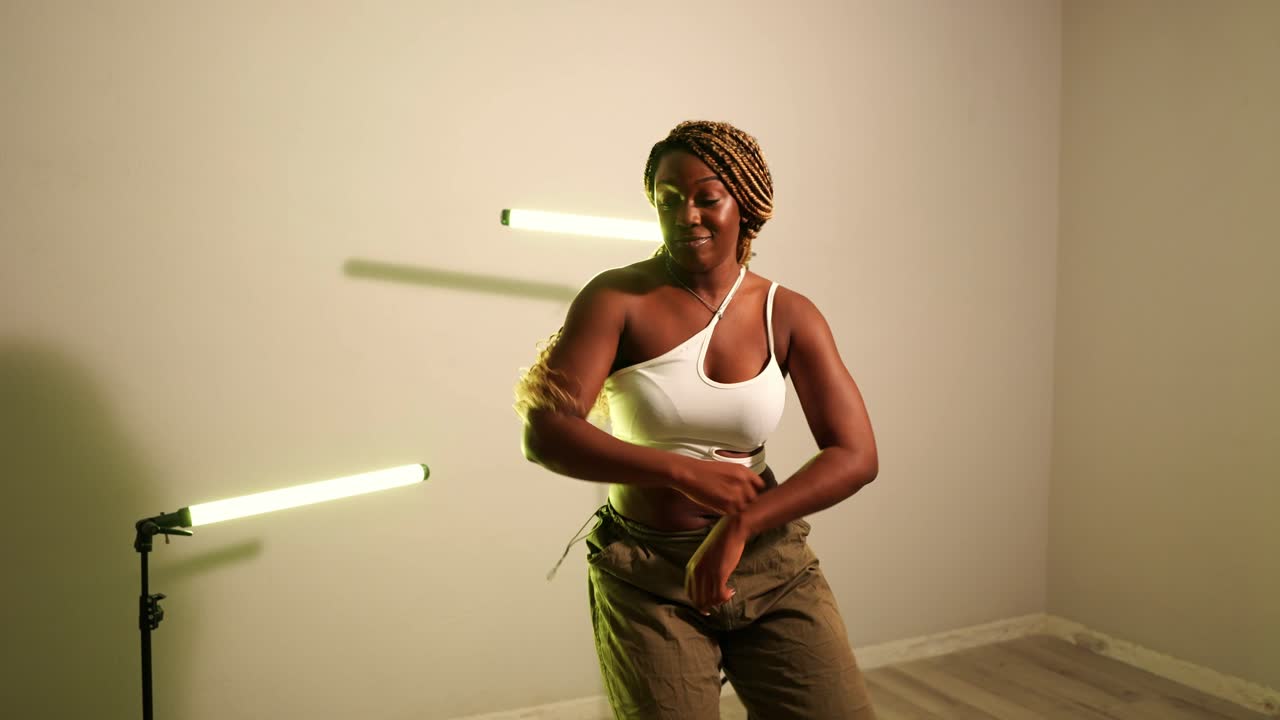 Donna che balla in studio con luci a tubo