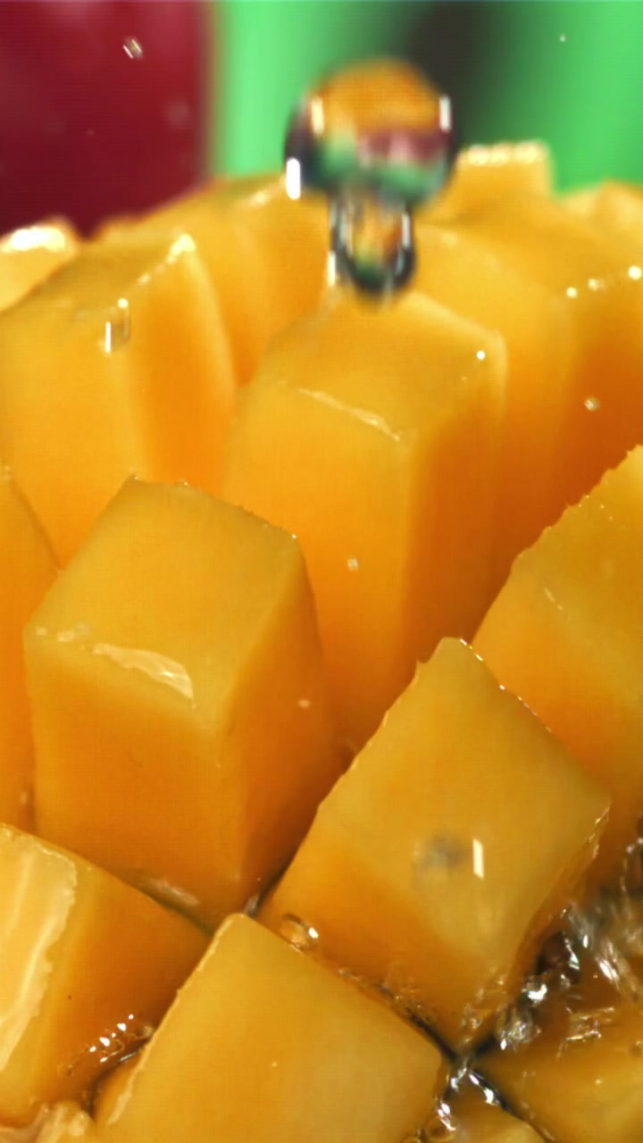 Woda rozpryskująca się na świeże kostki mango w zwolnionym tempie