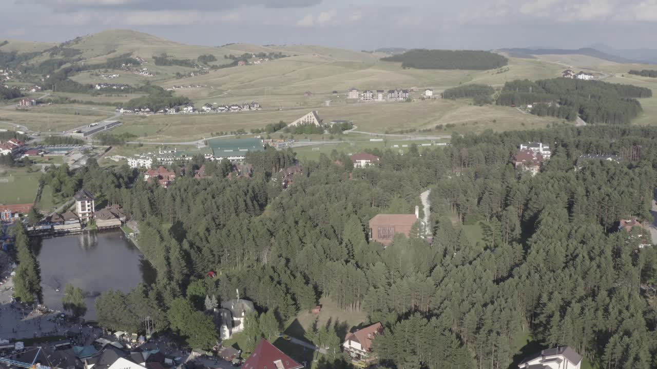 Aerial View of a Mountain Resort with Lake and Surrounding Forest