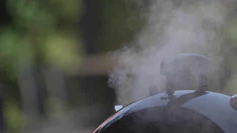 Smokes-Came-Out-From-A-Barbecue-Grill-Lid-With-Handle-In-Bokeh-Background