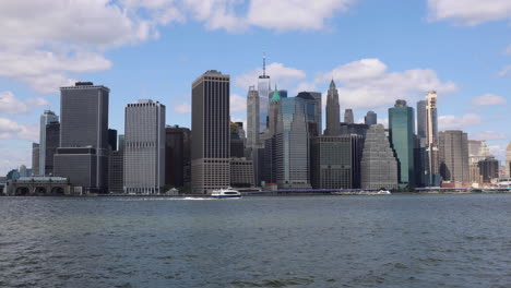 Capture-La-Impresionante-Vista-Del-Centro-De-Nueva-York-Desde-Brooklyn,-Con-Barcos-Deslizándose-Sobre-El-Agua