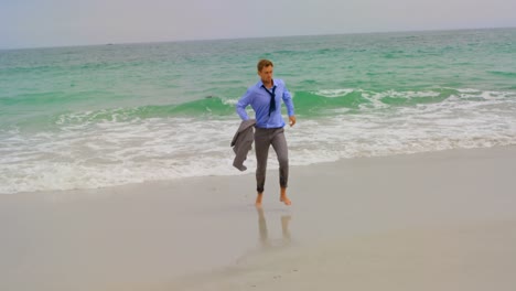 rear view of caucasian businessman running with blazer on the beach 4k