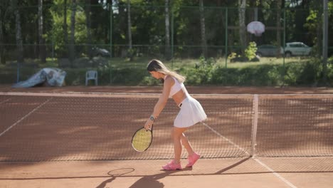 jugadora de tenis practicando el servicio en la cancha al aire libre